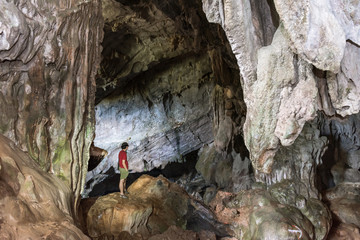 Young man exploring hugh cave.