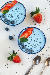 Blue yogurt smoothie made with blue spirulina powder, strawberries and blueberries.