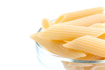 Raw feathers macaroni in bowl. Italian pasta close up, isolated on the white background