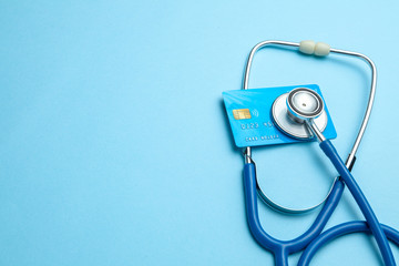 Credit card with stethoscope on blue background. The concept of medical strechevka or expensive medicine, doctors salary. Copy space for text. - obrazy, fototapety, plakaty