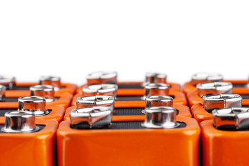 Many orange batteries, stand in several rows.  Isolated on white background