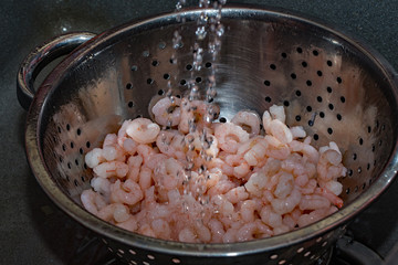 Rinsing fresh shrimp under cold water 