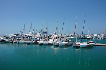 Fototapeta na wymiar Sea pier with several rows of yachts and boats