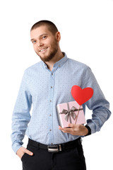 Young happy man holding red paper heart.