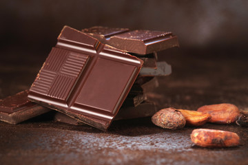 Broken dark chocolate and coffee beans on a wooden table