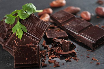 Broken dark chocolate and coffee beans on a wooden table