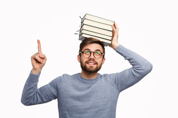 Student with books on head pointing up