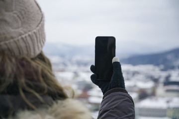 Junge Frau fotografiert Aussicht oder Selfie über Ljubljana im Winter