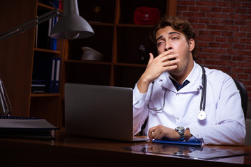 Young handsome doctor working night time at the hospital 