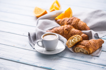 Fresh buttery croissants with coffee. Sweet morning breakfast concept.