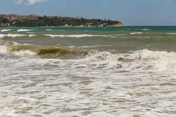 Rest on the Black Sea coast in Bulgaria. The town of Byala in the bright sunlight. European recreation area.  Waves during a storm. Red code. 