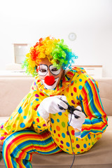Male clown preparing for perfomance at home 