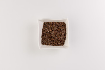 Flax seeds in bowl isolated on white background
