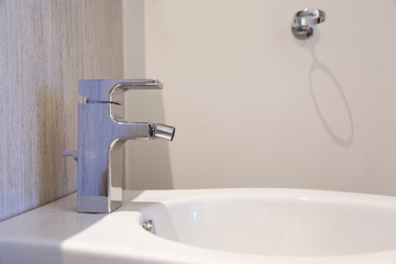 White ceramic bidet in modern bathroom.