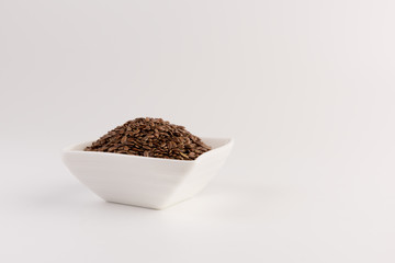Flax seeds in bowl isolated on white background