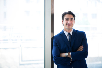 Young handsome businessman standing at the window 