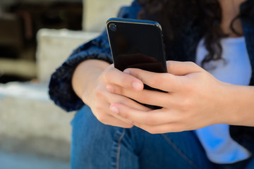 Young women sending message with smartphone.
