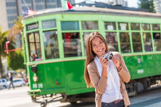 San Francisco cable car tramway woman tourist taking pictures of popular attraction vintage tram by the harbor. Asian girl photographer traveling in California, USA travel.