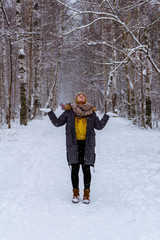 Naklejka premium girl catches snowflakes in the winter park