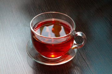 hot black tea in a Cup on a dark brown wooden table