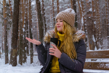 Fototapeta na wymiar girl with hot drink in winter park
