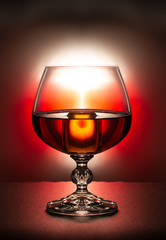 A glass of brandy on a red background