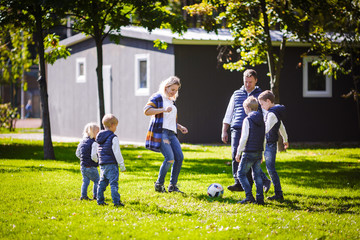 October 6, 2018 Ukraine. Kiev. theme family outdoor activities. big friendly Caucasian family six mom dad four children playing football, running ball on lawn, green grass lawn near house sunny day