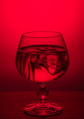 A glass of brandy on a red background