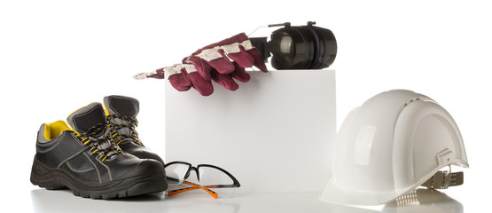 Work safety and protection equipment - protective shoes, safety glasses, gloves and hearing protection over white