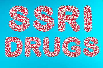 inscription ssri drugs white and red pills on a blue background top view. concept of Selective serotonin reuptake inhibitors