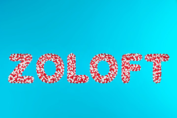 inscription zoloft white and red pills on a blue background top view. concept of medication and pharmaceuticals painkillers stress relieving antidepressants