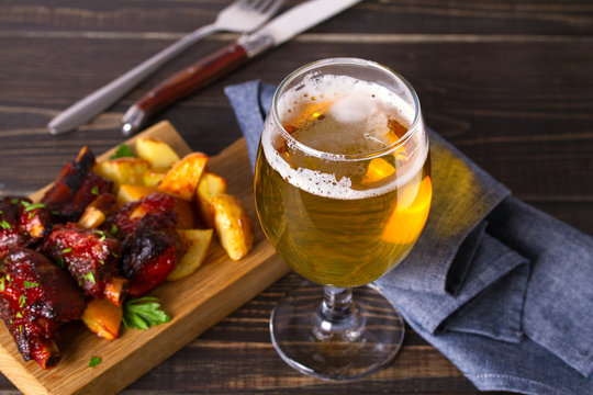 Glass of beer and grilled pork spare ribs with fry, tasty snack to beer. Beer and food concept. Ale and meat