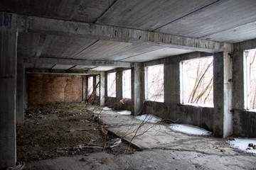 Fototapeta na wymiar Neglected ruins of unfinished corps of building of plant..