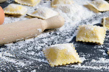 Process of making italian ravioli, close up on a black backgound