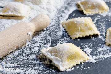 Process of making italian ravioli, close up on a black backgound