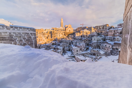 panoramic view of typical stones Sassi di Matera and church of Matera 2019 under blue sky with clouds and snow on the house, concept of travel and christmas holiday,capital of europe culture 2019