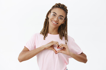 Waist-up shot of cute attractive and friendly african american girlfriend with dreads in pink...