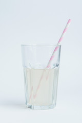 Fresh coconut water in transparent glass with straw.