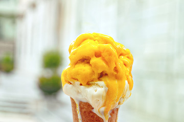 melted yellow and white ice cream on background of Spanish city of Tarragona close-up