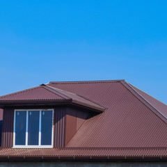 House with plastic windows and a brown roof of corrugated sheet