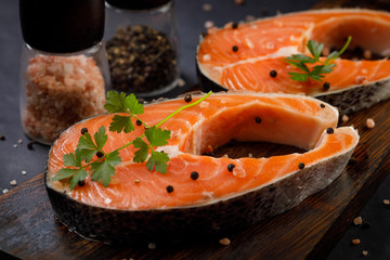 Salmon steak with pepper mill and salt mill on black