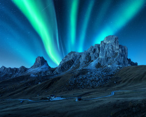 Northern lights above mountains at night in Europe. Aurora borealis. Starry sky with polar lights...