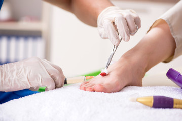 Obraz na płótnie Canvas Podiatrist treating feet during procedure
