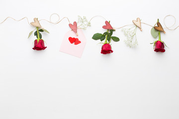 Flowers composition. Frame made of red rose on white background. Flat lay, top view, copy space.