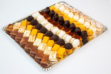 many different cupcakes in a tray on white background