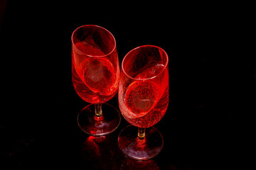 Two glasses with a pink drink juice jelly. Dark background.