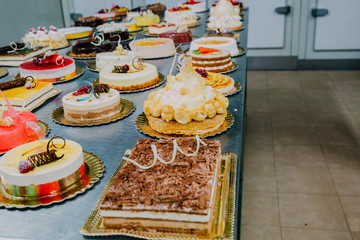 many cakes prepared on the metal table of a food factory
