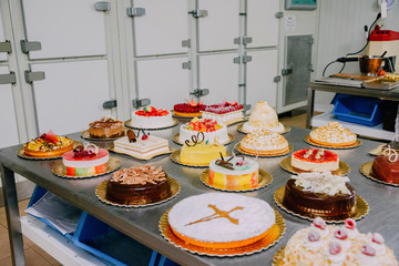 many cakes prepared on the metal table of a food factory