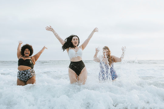 Three women jumping in sea waves