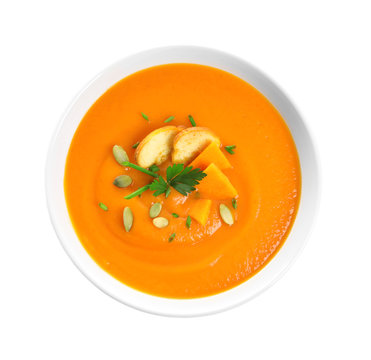 Dish with pumpkin cream soup on white background, top view. Healthy food
